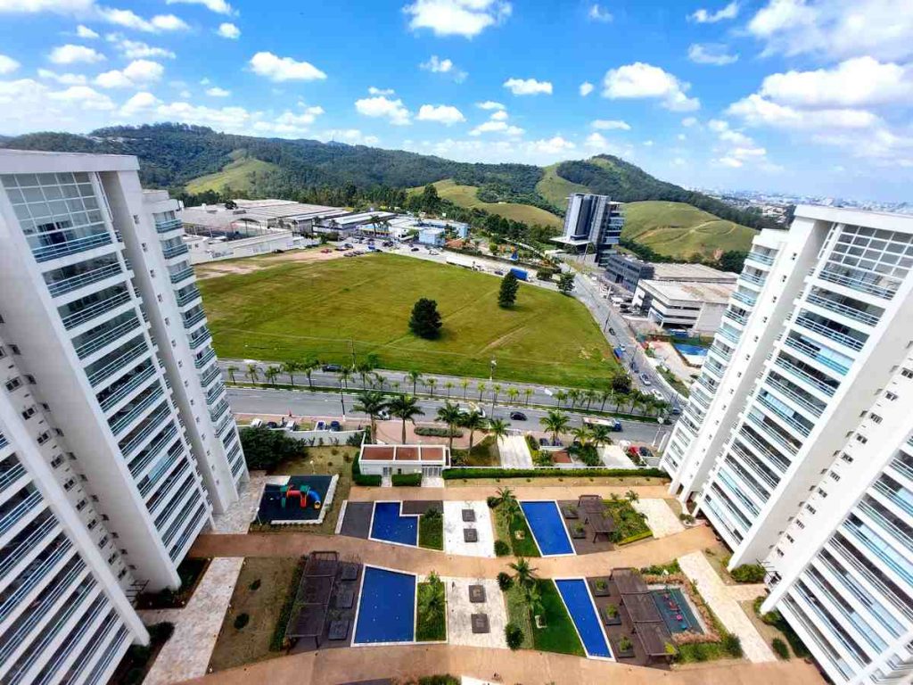 Vista aérea de condomínio moderno com torres residenciais, áreas de lazer e piscina, em artigo de blog sobre gestão inteligente de condomínios em ambientes urbanos