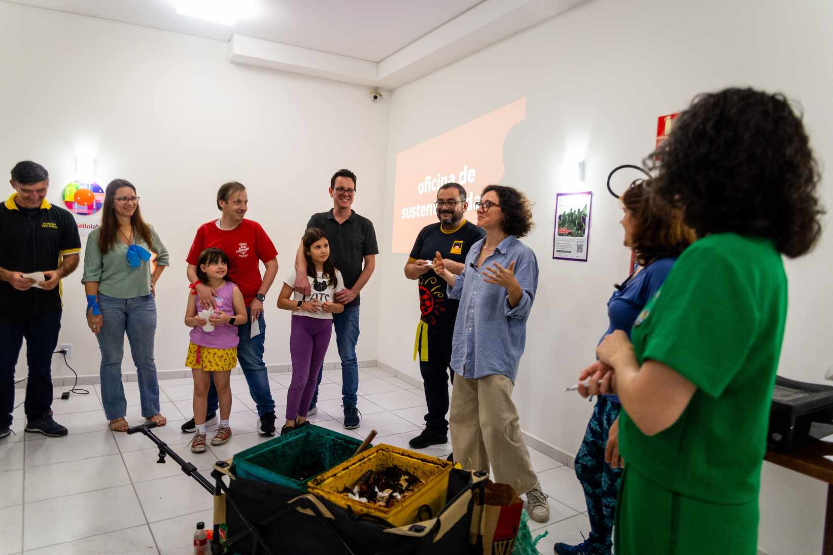 Imagem de grupo de moradores reunidos em oficina de descarte consciente e reciclagem, promovendo aprendizado sobre impacto social em condomínios